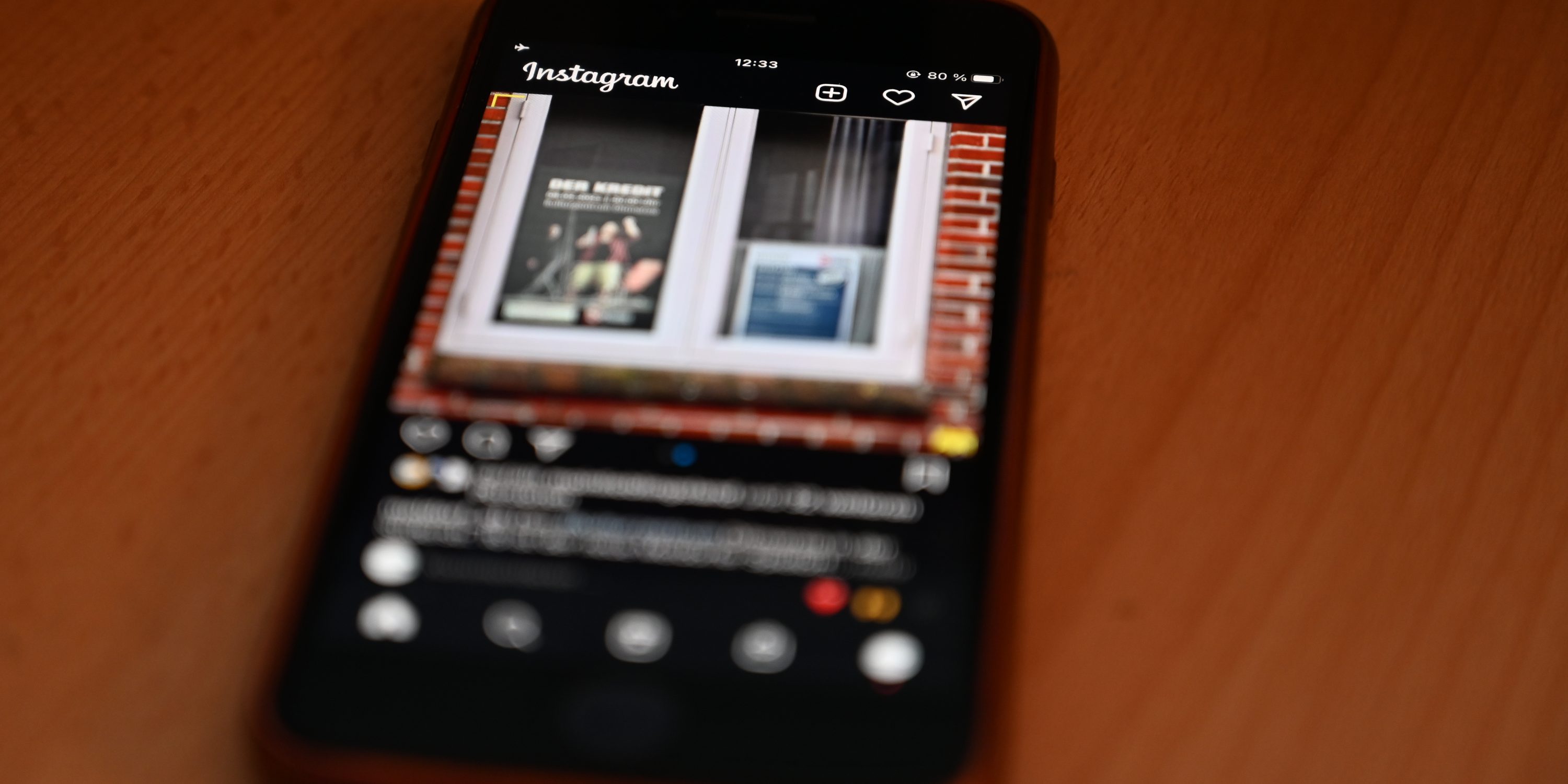 Ein Smartphone liegt auf dem Tisch. Die App Instagram ist geöffnet.