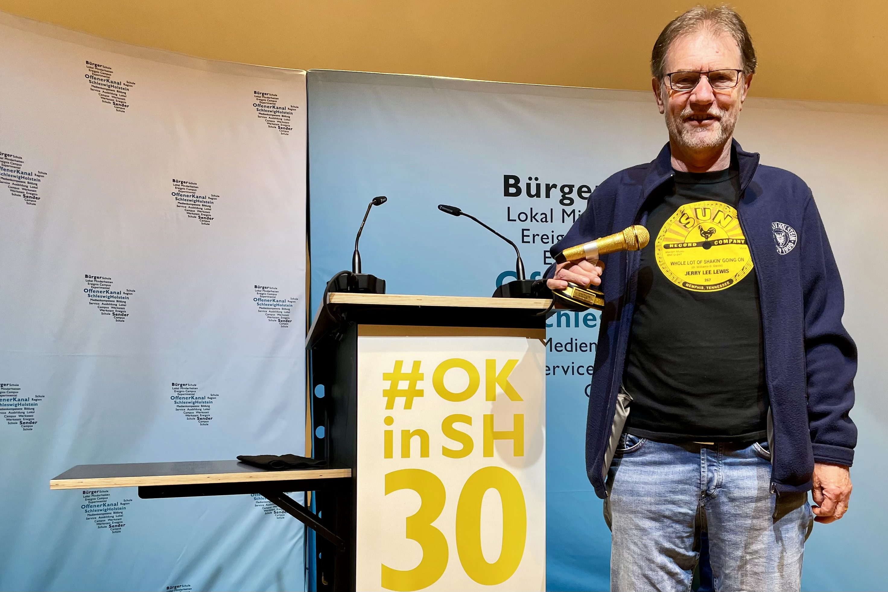 Gerd Muesfeldt mit dem Goldenen Mikrofon 2022 Gerd Muesfeldt wurde beim 30 jährigen OKSH Geburtstag das Goldene Mikrofon für seine Sendung "Teen Beat - damals" erhalten.