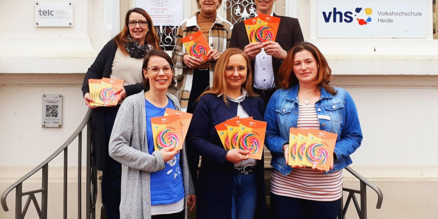 VHS Heide stellt Frühjahrsprogramm vor Auf den Stufen der VHS Heide wird das neue Programm für das Frühjahr und den Sommer in die Kamera gehalten